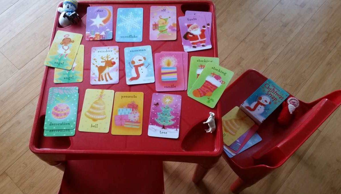 A red table showing a game of snap in progress using Usborne Christmas Snap cards
