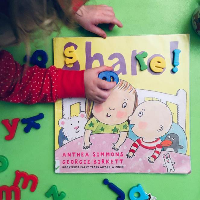 A child places a magnet on the picture book Share! by Anthea Simmons and Georgie Birkett