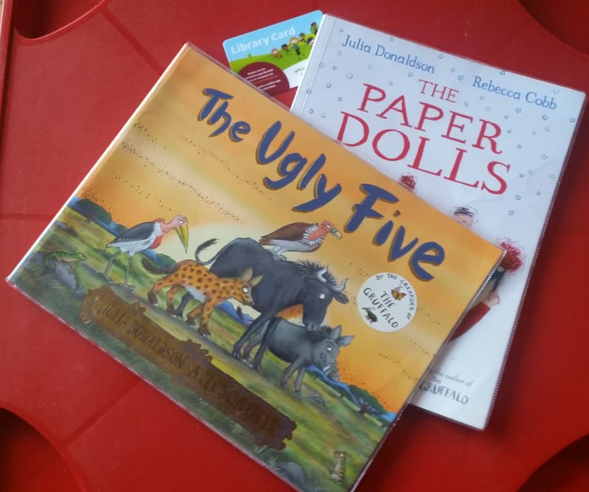 Copies of two library books: The Ugly Five by Julia Donaldson and Axel Scheffler and The Paper Dolls by Jilia Donaldson and Rebecca Cobb