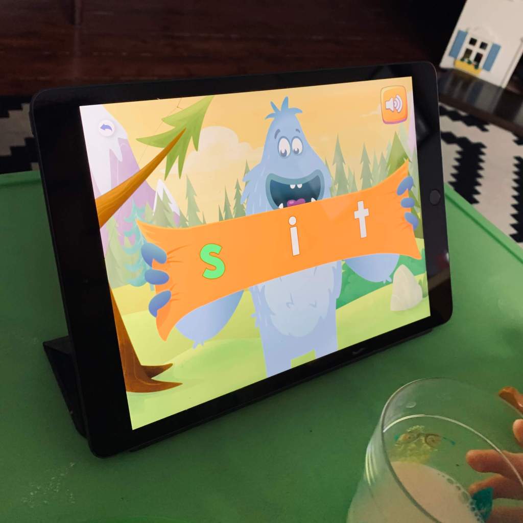 An iPad shows an image from a lesson on the Reading Eggs app