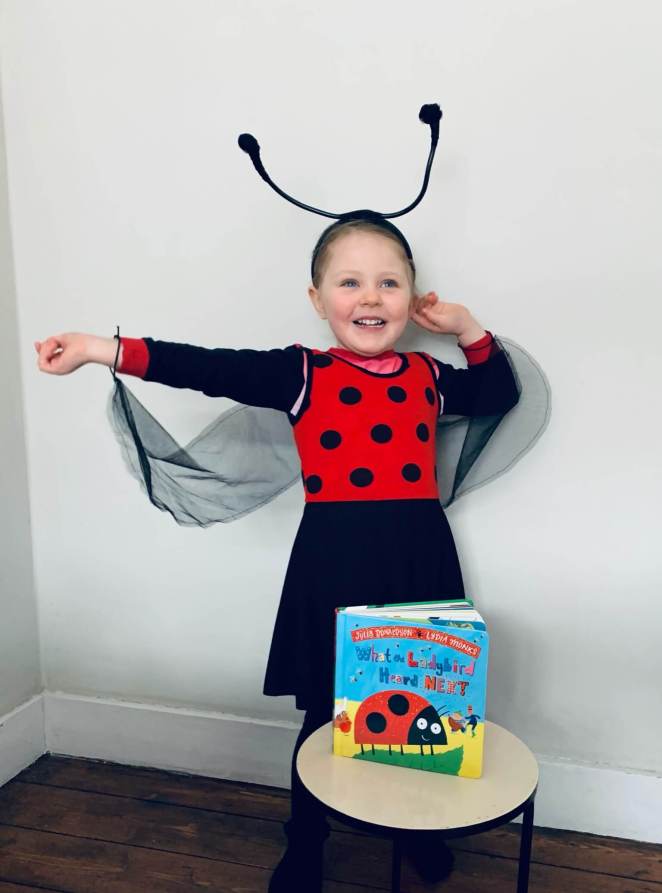 A girl is dressed for World Book Day as the ladybird from What the Ladybird Heard by Julia Donaldson and Lydia Monks 
