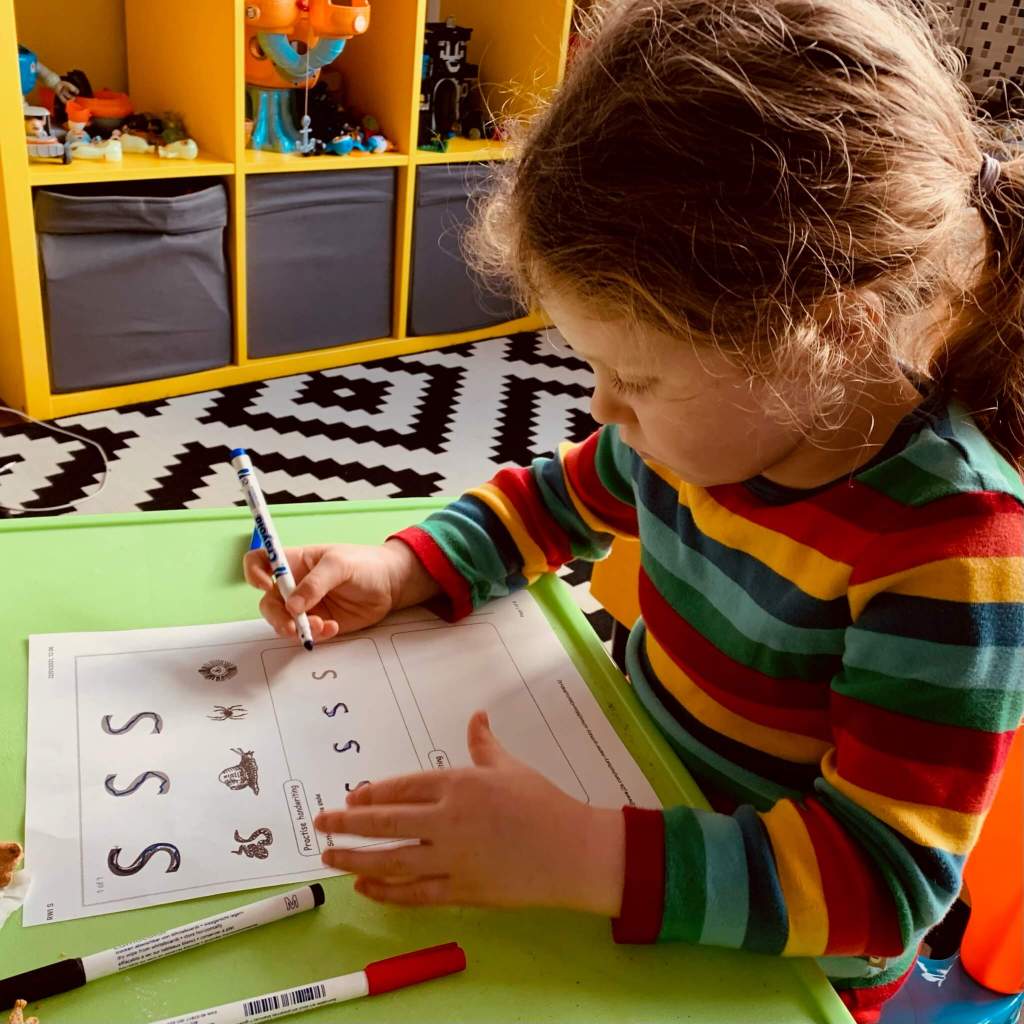 A preschooler practices writing the letter S