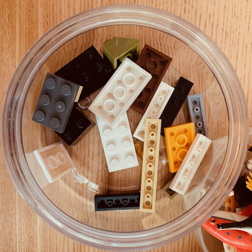 A collection of lego bricks in a small plastic pot