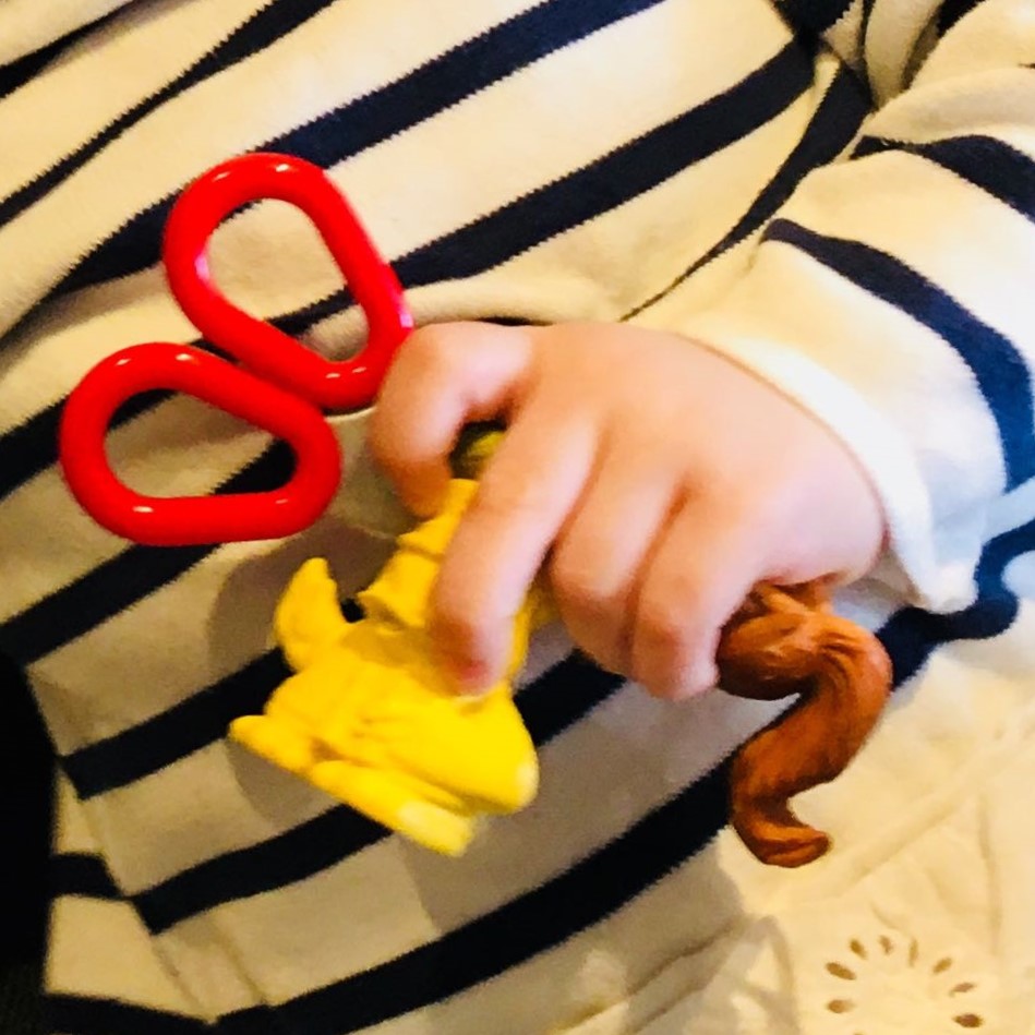 A child's hand clutching toys